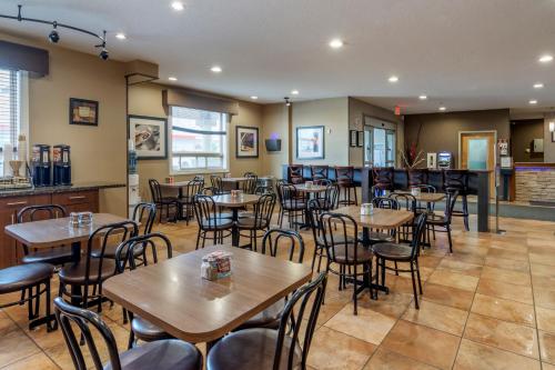 un ristorante con tavoli e sedie e un bar di Devonian Hotel and Suites a Fox Creek