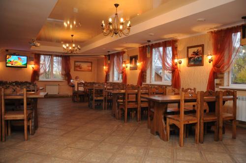 a dining room with wooden tables and chairs at Hotel Akkerman in Oryol