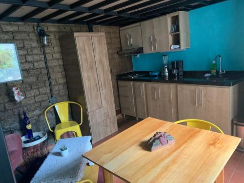 a kitchen with a wooden table and yellow chairs at Moonshine Boutique Hostal in Cali