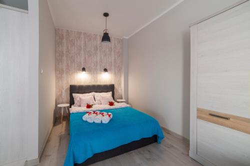 a bedroom with a blue bed with three bowls on it at STOP Apartment in Suwałki