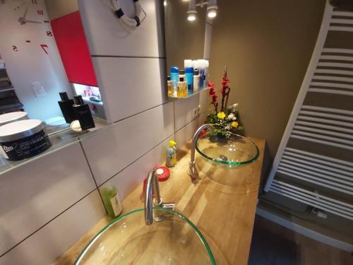 een badkamer met een wastafel met een vaas met bloemen bij Magnifiques chambres d'hôtes au grand air in Anhée