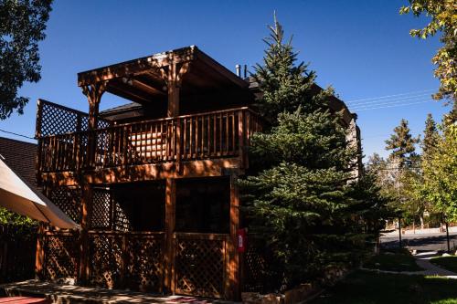 Cabaña de madera con balcón y árbol en Embers Lodge & Cabins en Big Bear Lake