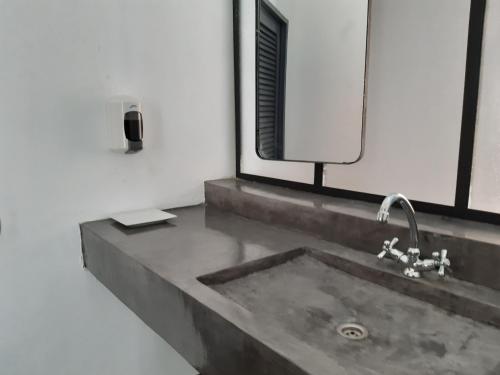 a bathroom with a sink and a mirror at Siki Hotel in Saint-Louis