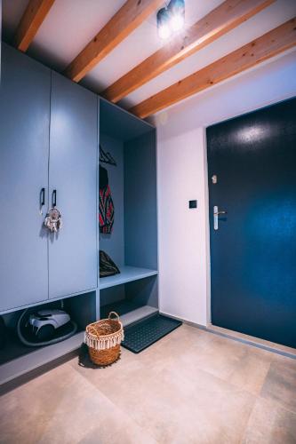 a room with a black door and a wicker basket at Domki 4 Nad Ranem - Baza Bieszczady Smerek in Smerek