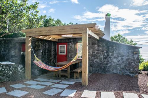 a hammock under a pergola on a patio at Aldeia Dos Caldeirões in São Mateus