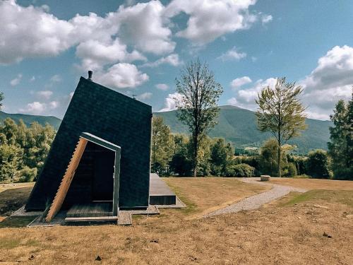 a small building sitting on top of a field at Domki 4 Nad Ranem - Baza Bieszczady Smerek in Smerek