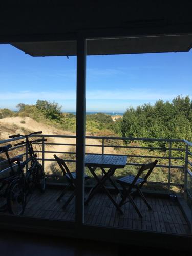 a table and chairs on a balcony with a view of the ocean at Les pieds dans le sable in Malo-les-Bains