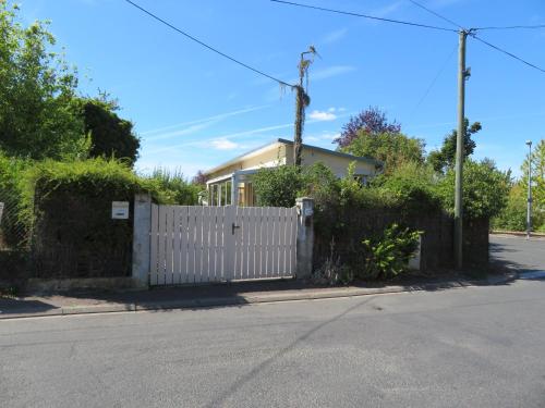 a white fence in front of a house at Gîte La Pierre Qui Tourne in Amboise