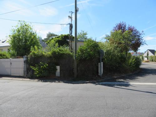 a street corner with a fence and a street sign at Gîte La Pierre Qui Tourne in Amboise