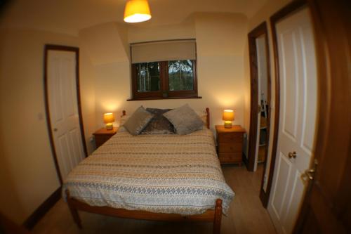 Hooters Apartment EV Point في ويدبريدج: غرفة نوم بسرير كبير مع وجود مصباحين على الطاولات