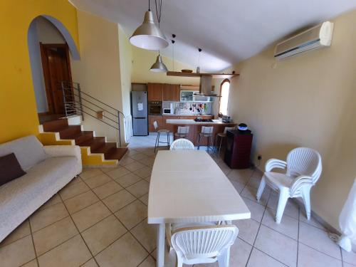 a living room with a white table and chairs at Villetta immersa nella tranquillità in Capitana