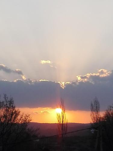 a sunset with the sun poking through the clouds at Atardecer Serrano in Huerta Grande