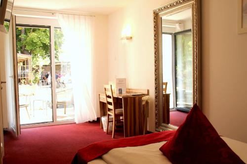 a room with a mirror and a table and a bed at Hotel Bruckertshof in Bamberg