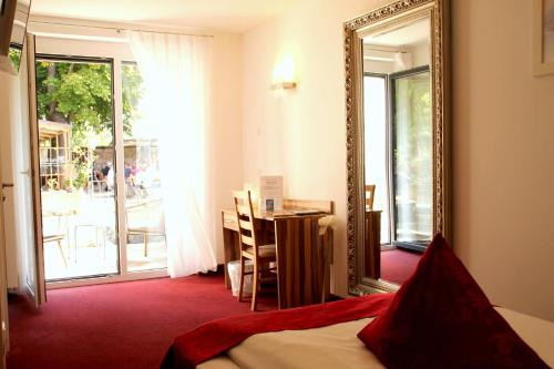 Zimmer mit einem Spiegel, einem Tisch und einem Bett in der Unterkunft Hotel Bruckertshof in Bamberg