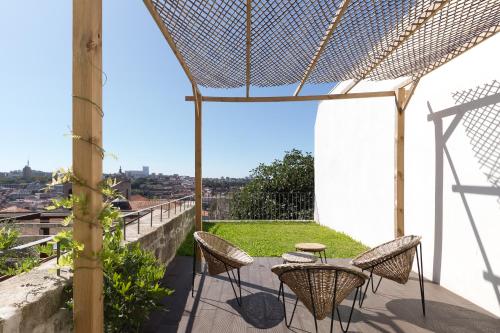 um pátio com cadeiras e uma mesa na varanda em Douro Virtudes Apartments Historical Center no Porto