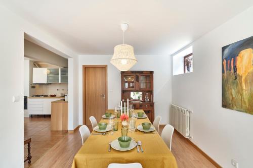 a dining room with a table and chairs and a kitchen at Casa da Avó Amália in Janeiro de Cima
