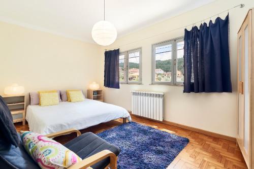 ein Schlafzimmer mit einem Bett und einem blauen Teppich in der Unterkunft Casa da Avó Amália in Janeiro de Cima