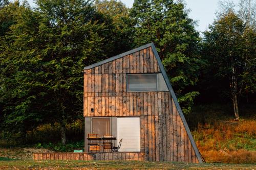 a small wooden house with a door and a window at Domki 4 Nad Ranem - Baza Bieszczady Smerek in Smerek