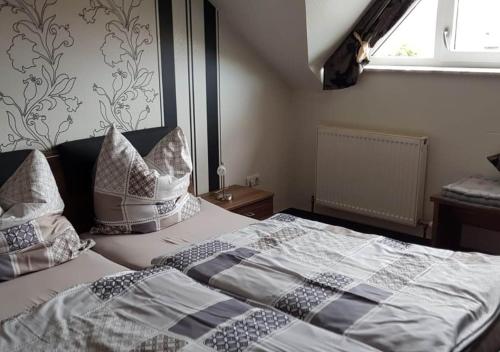 a bedroom with a bed with pillows and a window at Ferienwohnung Weiß Weinberg in Wachenheim an der Weinstraße