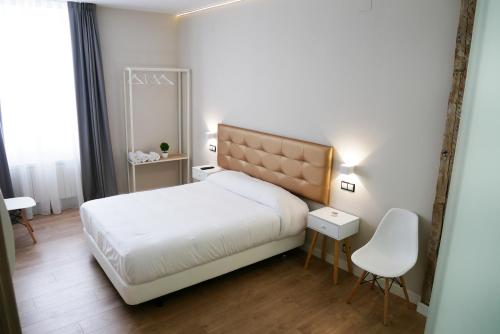 a bedroom with a white bed and a white chair at ART BURGOS in Burgos