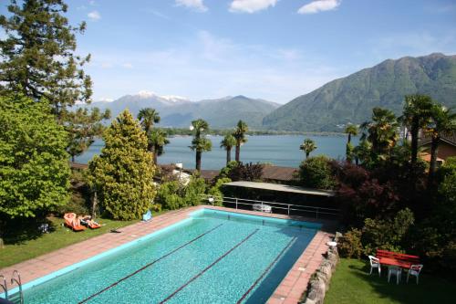 a swimming pool with a view of a lake and mountains at Residenza Paradiso di Vacanze in Locarno