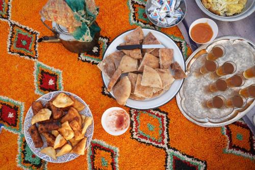 a table topped with plates of food and dips at Bivouac Les Nomades & Foum zguid to chegaga tours in Foum Zguid