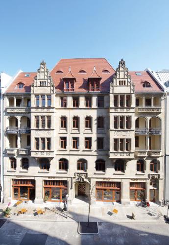 a large white building with a red roof at Apartmenthotel Quartier M in Leipzig