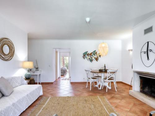 a living room with a white couch and a table at Aroeira Golf - Beach House in Carcereiro