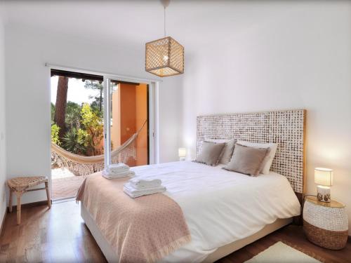 1 dormitorio con 1 cama grande y ventana grande en Aroeira Golf - Beach House, en Carcereiro