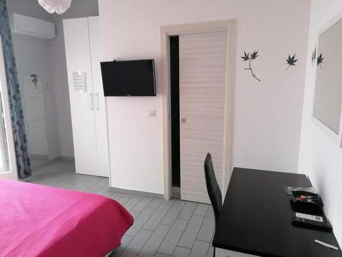 1 dormitorio con cama, mesa y TV en Casa Normanna en Monreale