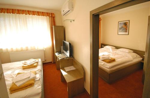 a hotel room with two beds and a mirror at Hotel Bavaria in Abda