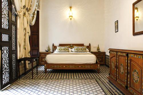 a bedroom with a bed and wooden furniture at Le Grand Alcazar - Riad in Fès