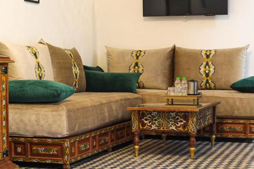 a living room with a couch and a coffee table at Le Grand Alcazar - Riad in Fès