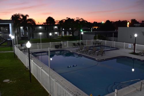 a swimming pool at night with a fence and lights at Super 8 by Wyndham Ocala I-75 in Ocala