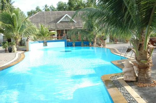 a large blue swimming pool with a palm tree at Rajapruek Samui Resort - SHA Plus in Lipa Noi
