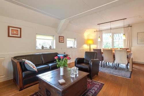 a living room with a couch and a table at Vakantiehuis Villa 63 in Heel