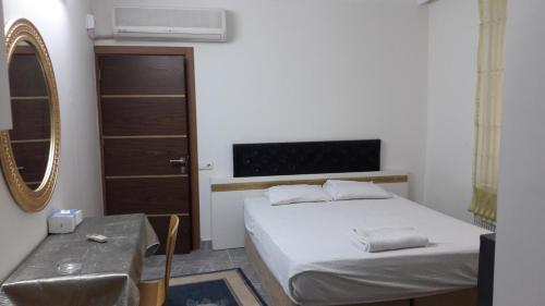 a small bedroom with a bed and a mirror at Gunay Pansiyon Antalya in Antalya
