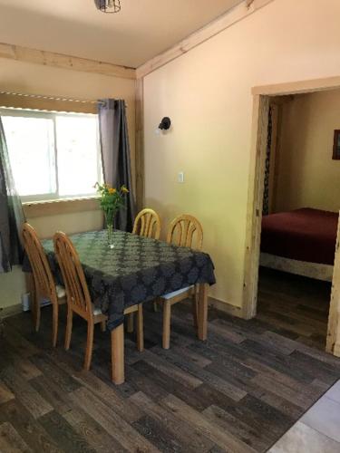 a dining room with a table and chairs and a bedroom at paradis sauvage geronimo in St-Etienne de Bolton