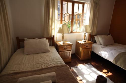 a bedroom with two beds and a window at Casa Los Jazmines in Sucre