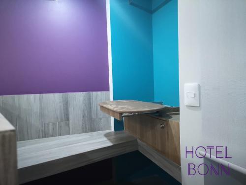 a bathroom with a wooden sink and a blue wall at Hotel Bonn in Mexico City
