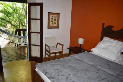 a bedroom with a bed and a chair and a balcony at Porto Grande Hotel & Convention in São Sebastião