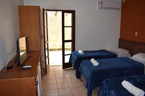 a hotel room with two beds and a television at Porto Grande Hotel & Convention in São Sebastião