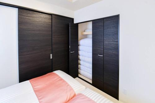 a bedroom with wooden cabinets and a bed at momo premium 702 in Sapporo