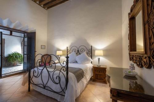 a bedroom with a bed with a wrought iron headboard at Hotel Layseca in San Juan del R&iacute;o
