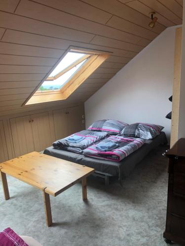 a bedroom with a bed and a table in a attic at Dachgeschoss in einem Reihenhaus (mit gemeinschaftlichen Räumen) in Heidelberg