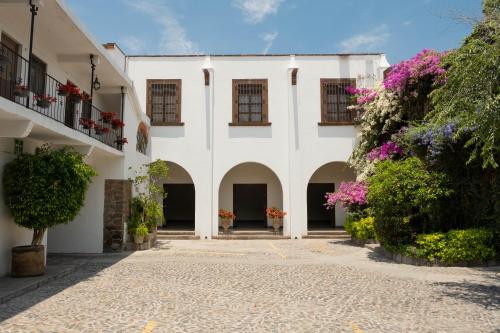 un patio de un edificio con flores y plantas en Hotel Layseca, en San Juan del Río