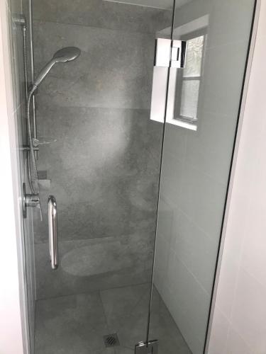 a shower with a glass door in a bathroom at Southern Comfort Motel in Christchurch