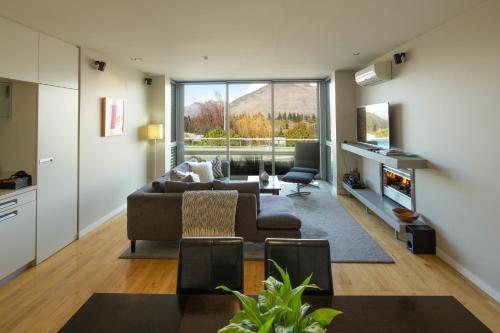 a living room with a couch and a table at Hello QT Pounamu in Queenstown