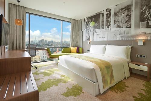 a bedroom with a large bed and a large window at Holiday Inn & Suites Saigon Airport by IHG in Ho Chi Minh City