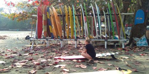 a woman sitting in front of a bunch of surfboards at anik homestay & dormy Batukaras in Batukaras